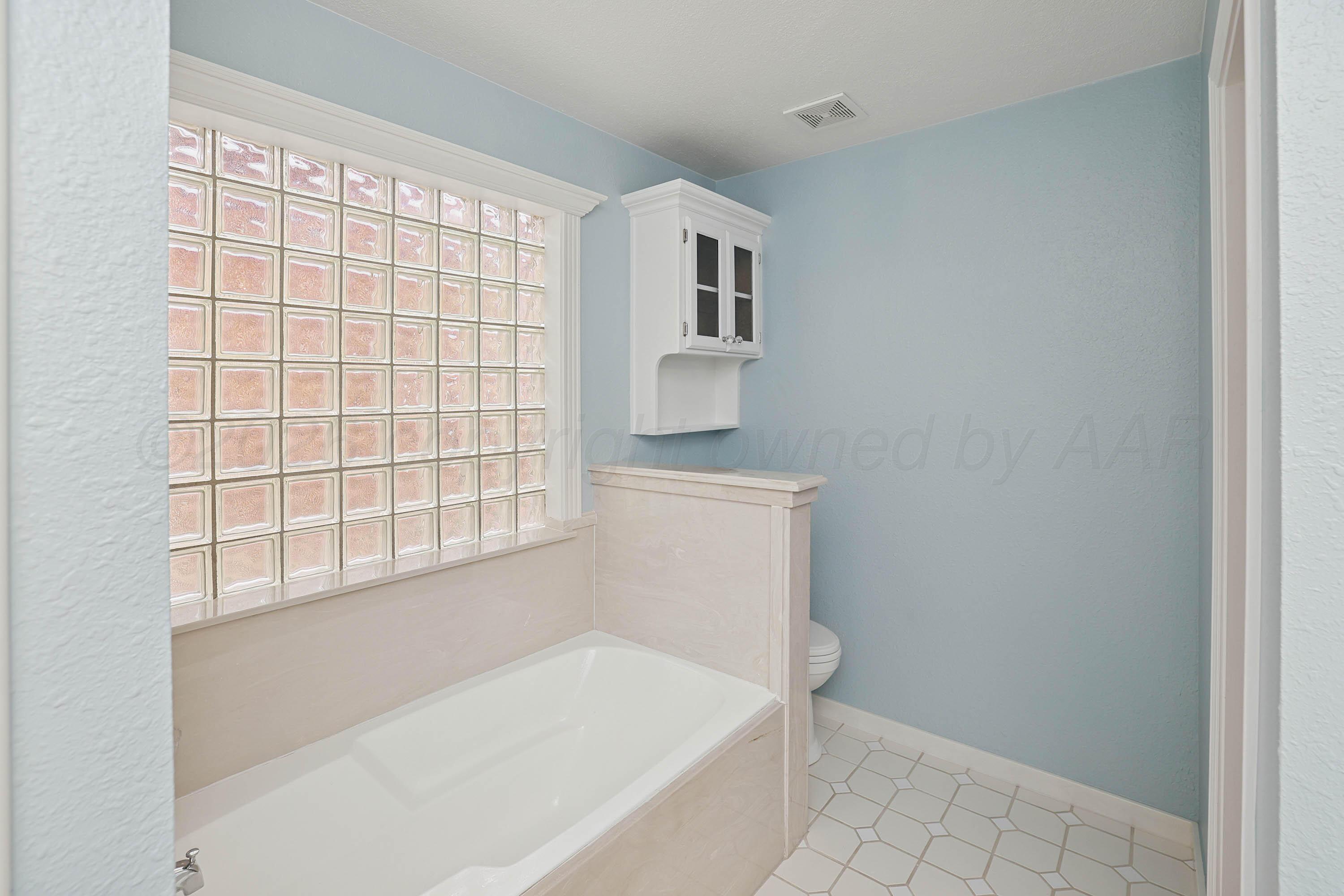 6904 Alpine Lane Amarillo, TX 79109 - Photo 15 of 45 a bathroom with a bathtub and window