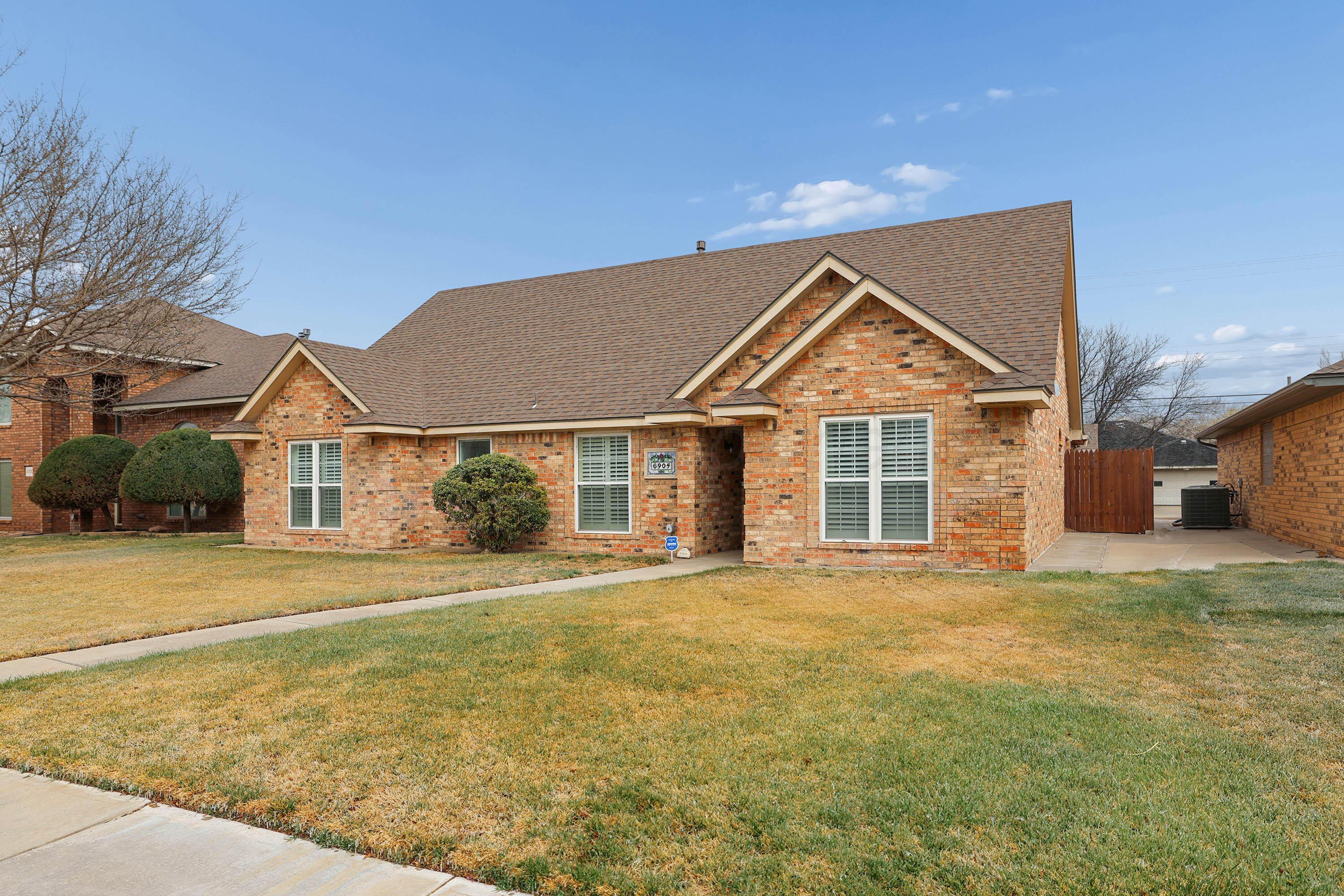 6904 Alpine Lane Amarillo, TX 79109 - Photo 2 of 45 a front view of a house with a yard and garage