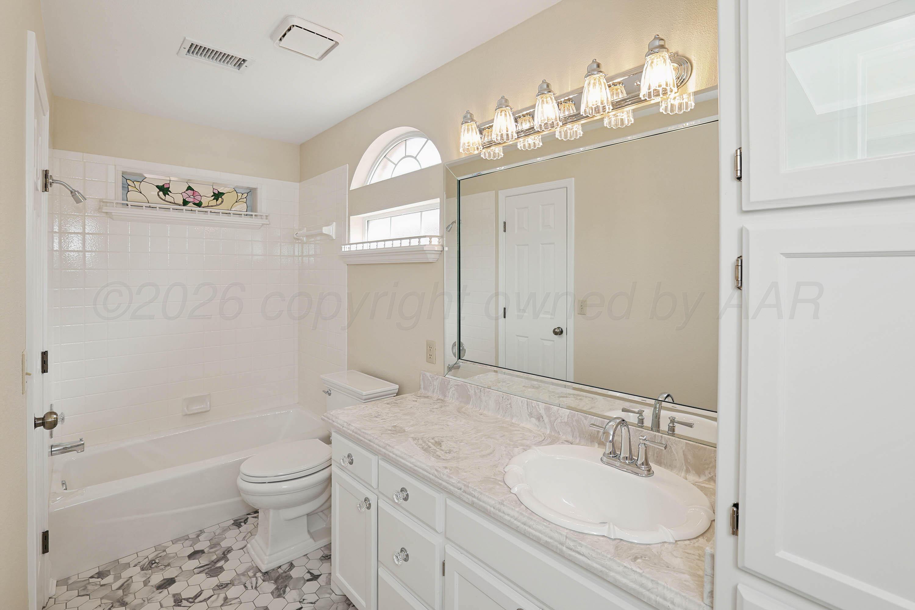 6904 Alpine Lane Amarillo, TX 79109 - Photo 21 of 45 a bathroom with a granite countertop sink a toilet and shower
