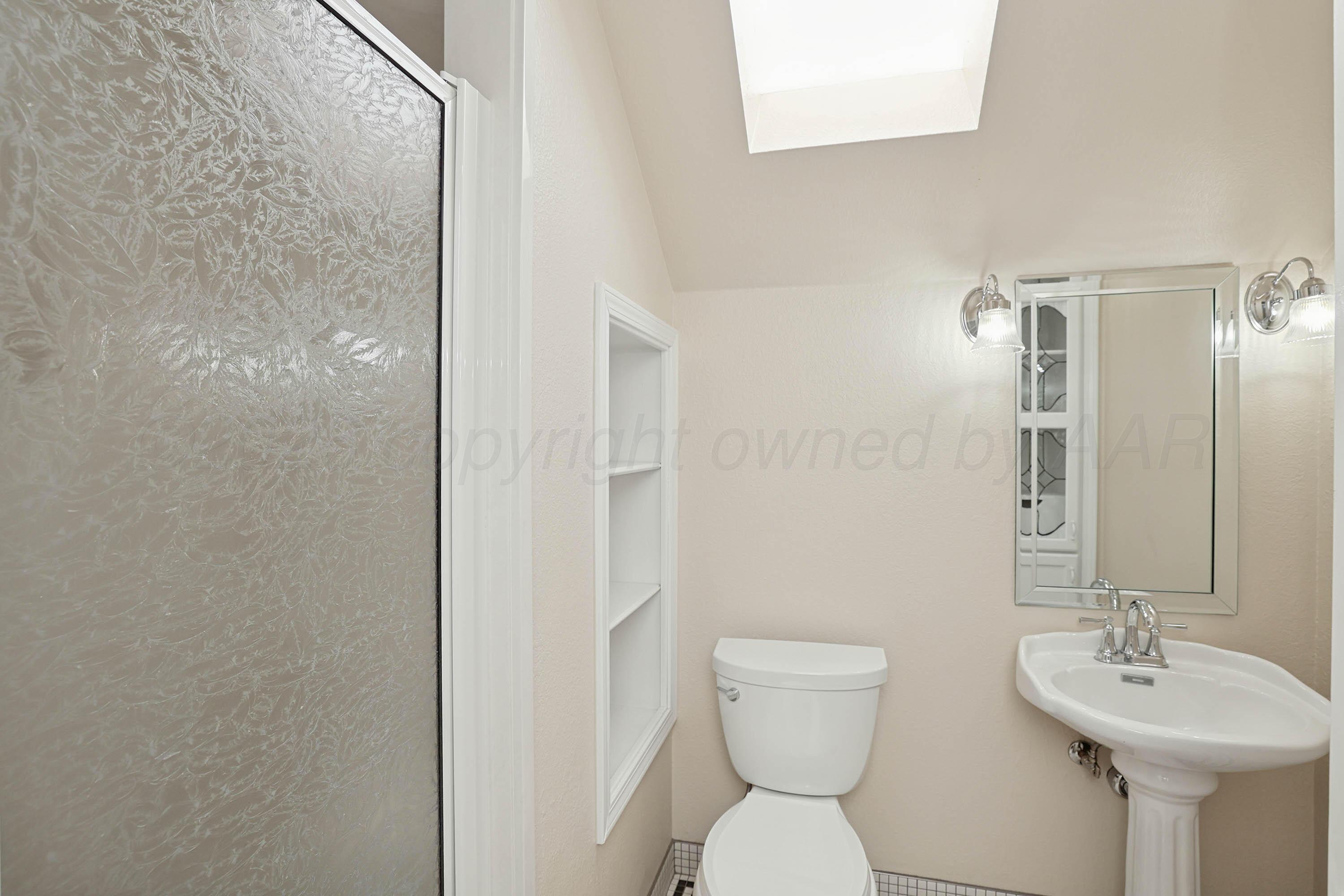6904 Alpine Lane Amarillo, TX 79109 - Photo 32 of 45 a bathroom with a toilet sink and mirror