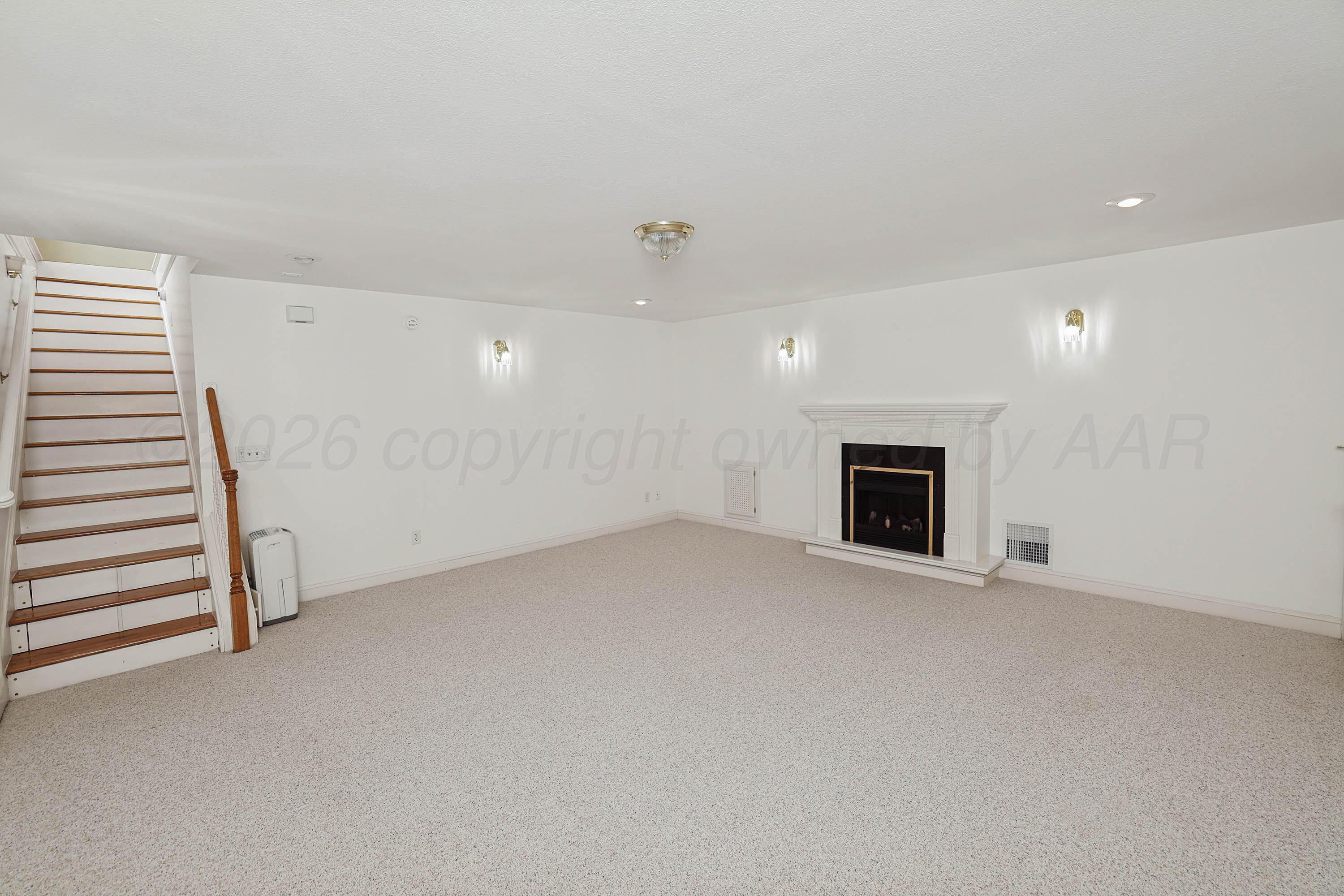 6904 Alpine Lane Amarillo, TX 79109 - Photo 36 of 45 an empty room with a fireplace and entryway