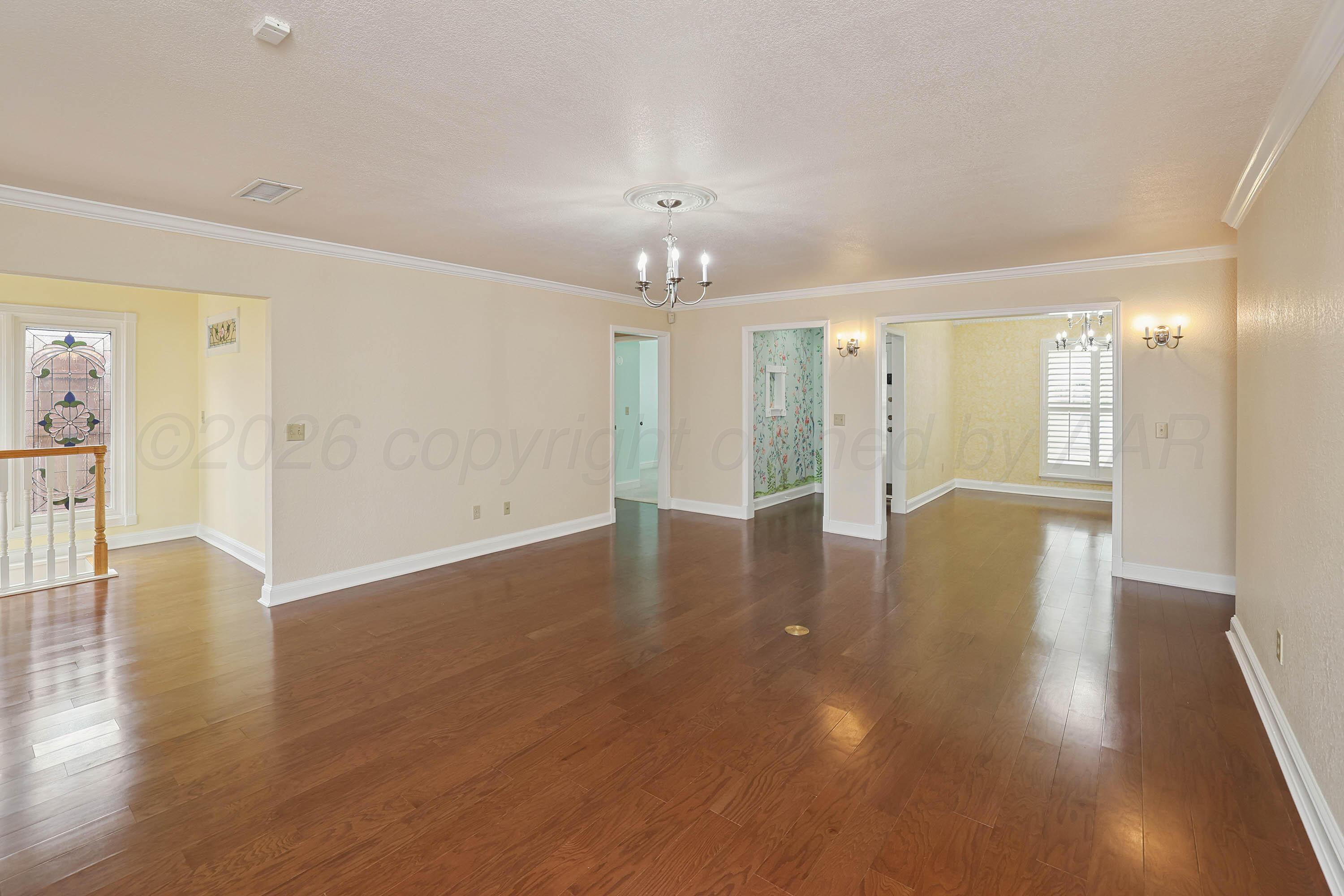 6904 Alpine Lane Amarillo, TX 79109 - Photo 5 of 45 a view of an empty room with wooden floor and a window