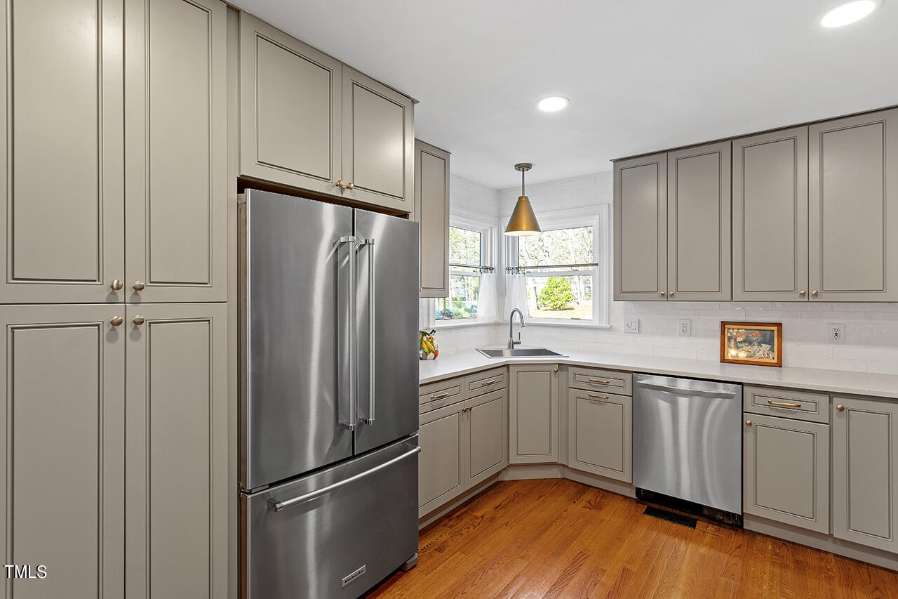 6933 Sandringham Drive Raleigh, NC 27613 - Photo 11 of 30 a kitchen with stainless steel appliances granite countertop a refrigerator sink and cabinets