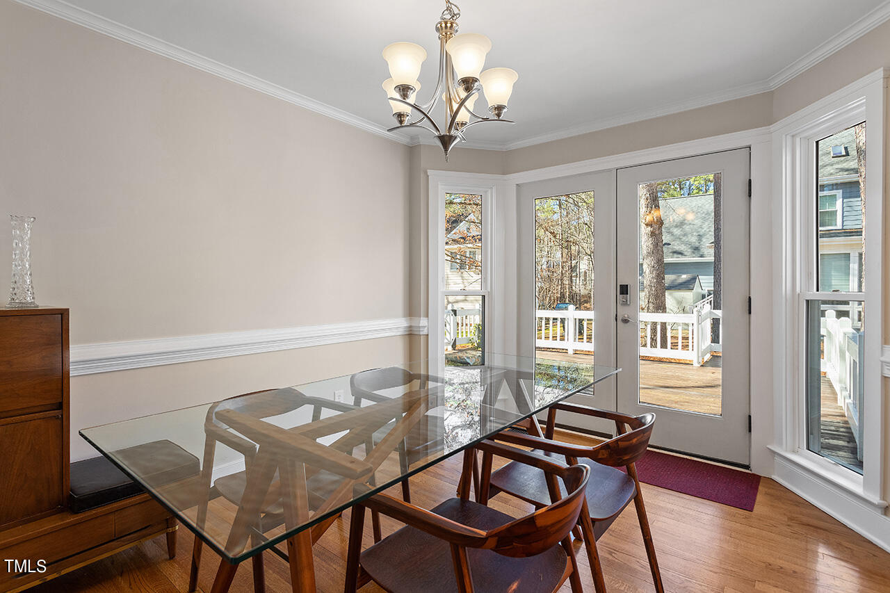 6933 Sandringham Drive Raleigh, NC 27613 - Photo 15 of 30 a view of a dining room with furniture wooden floor and chandelier