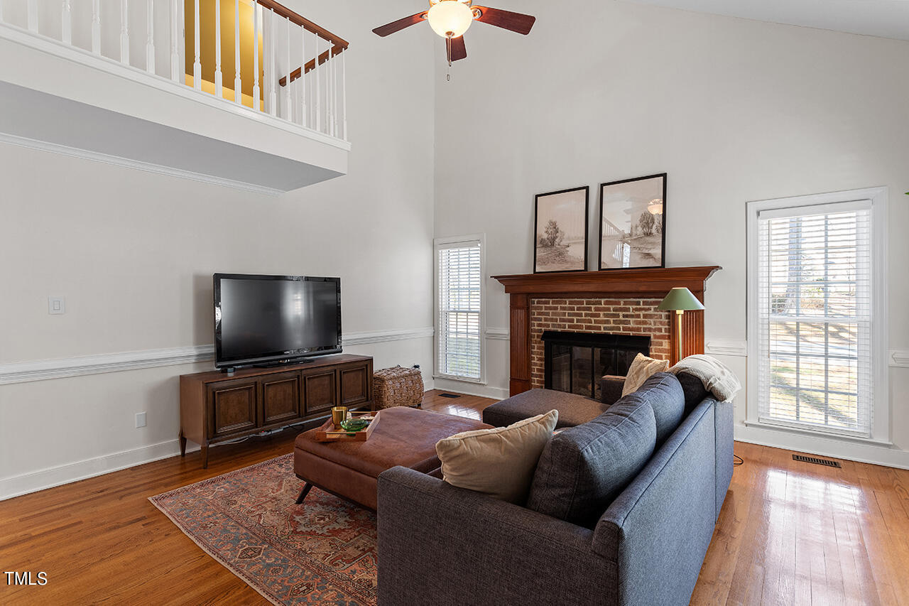 6933 Sandringham Drive Raleigh, NC 27613 - Photo 4 of 30 a living room with furniture a flat screen tv and a fireplace