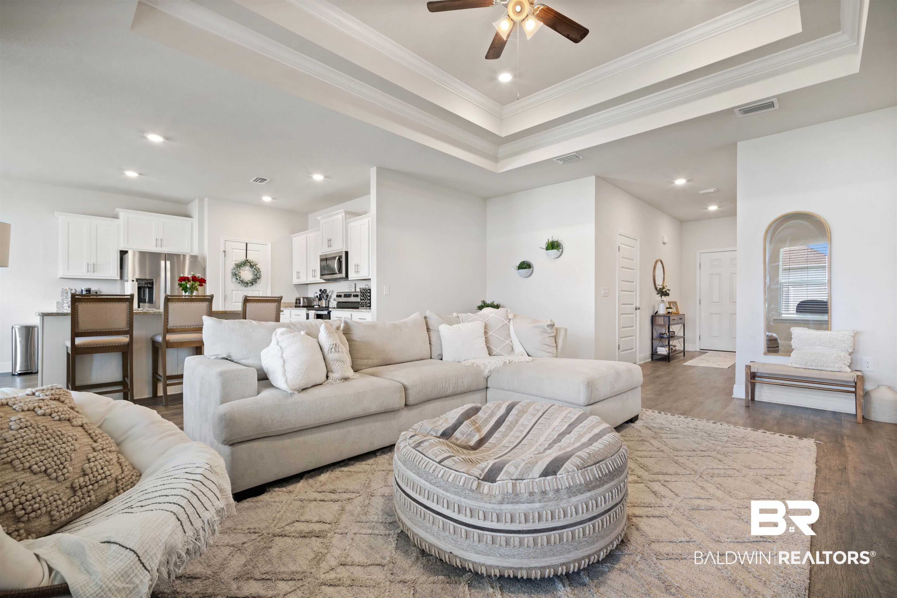 11021 Native Dancer Way Daphne, AL 36526 - Photo 6 of 35 Living room with crown molding, a ceiling fan, wood finished floors, a raised ceiling, and visible vents