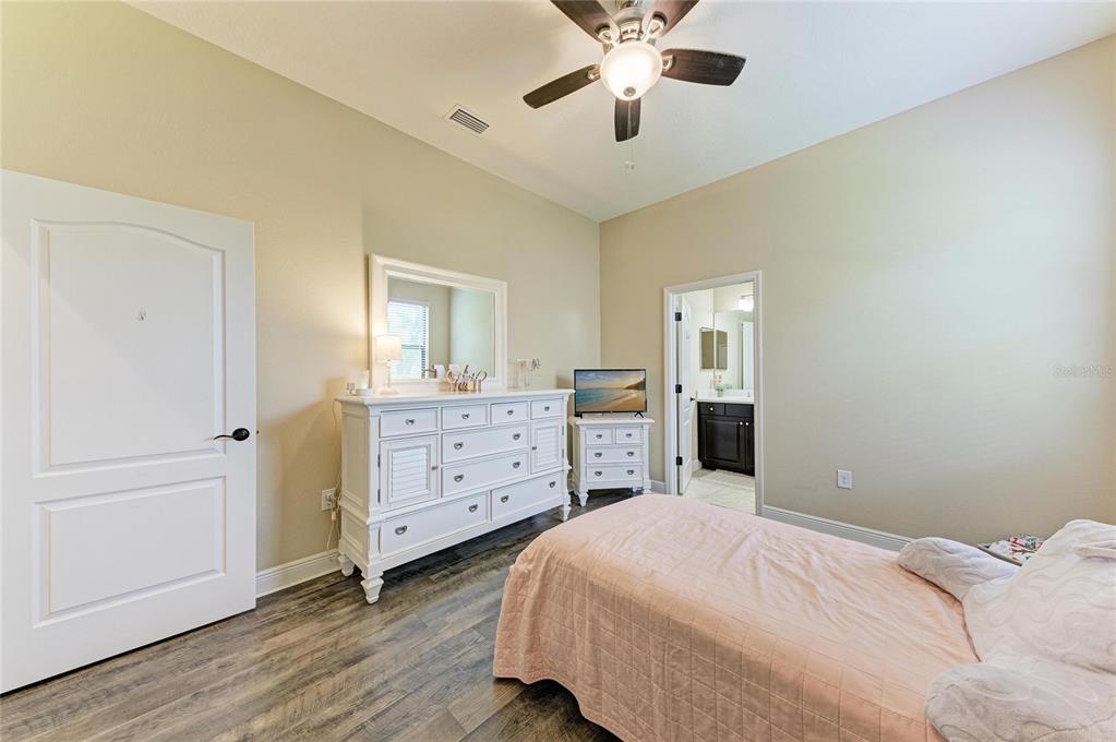 12642 Harney Street Venice, FL 34293 - Photo 31 of 85 a bedroom with a bed and a chandelier