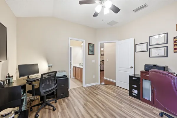 a view of a workspace with furniture and a window