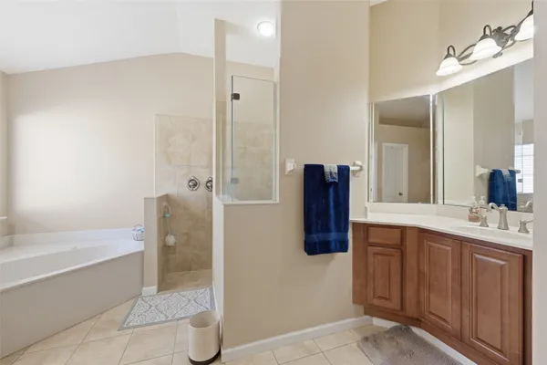 a bathroom with a tub sink and mirror