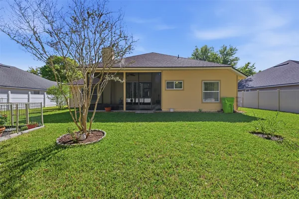a front view of a house with a yard and a tree