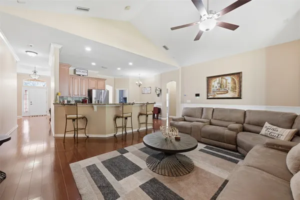 a living room with furniture and a view of kitchen