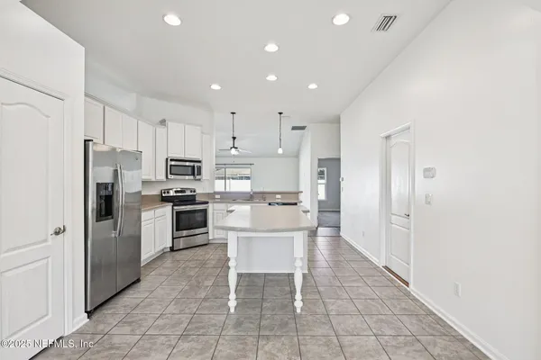 a kitchen with a refrigerator a sink and cabinets