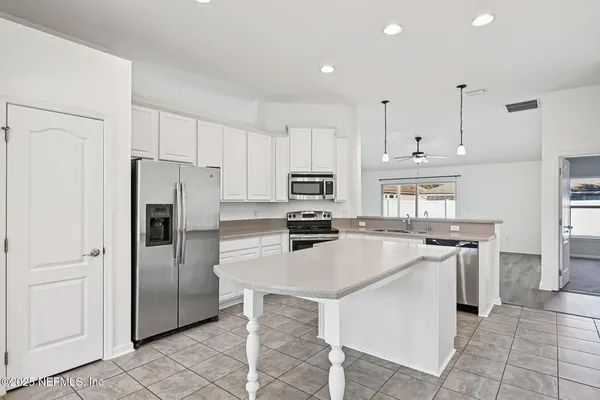 a kitchen with stainless steel appliances granite countertop a refrigerator stove top oven and sink