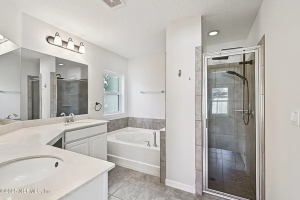 a bathroom with a tub a sink and mirror