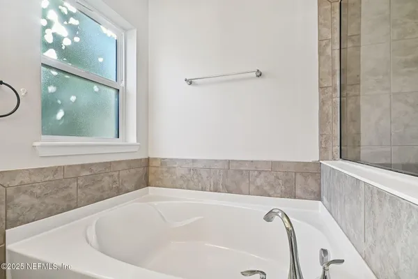 a bathroom with bathtub and window