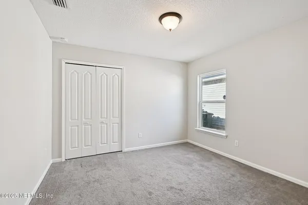 a view of backyard and floor to ceiling window