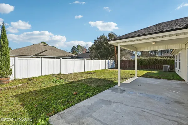 a view of a house with a backyard and a tree