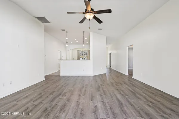 a view of a kitchen with wooden floor and a ceiling fan