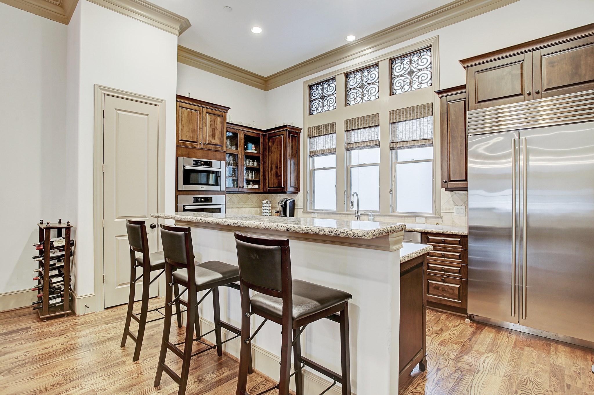 1307 Rosedale Street Houston, TX 77004 - Photo 16 of 32 a kitchen with stainless steel appliances granite countertop a stove top oven a refrigerator a dining table and chairs with wooden floor