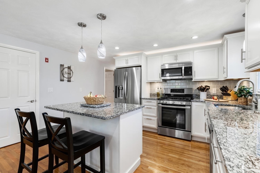 a kitchen with kitchen island granite countertop a table and chairs in it