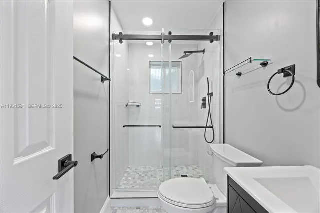 a bathroom with a granite countertop toilet sink and shower
