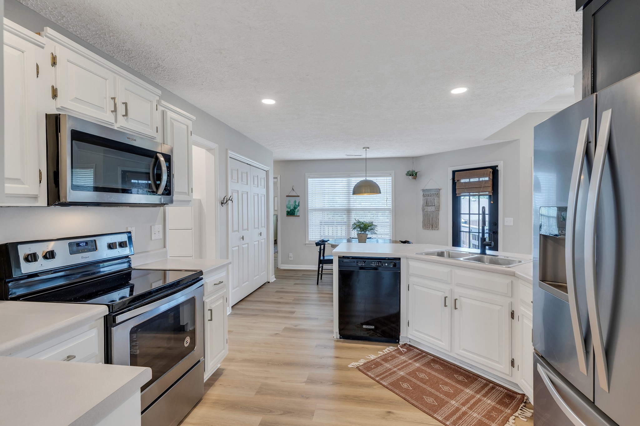 1213 Hunters Point Lane Spring Hill, TN 37174 - Photo 11 of 30 a kitchen with stainless steel appliances kitchen island granite countertop a stove sink and microwave