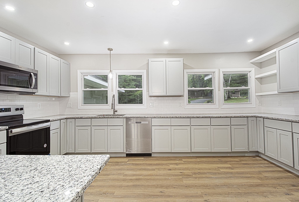 32 Aylesbury Road Worcester, MA 01609 - Photo 7 of 42 a kitchen with stainless steel appliances granite countertop a stove a sink a microwave a refrigerator and cabinets