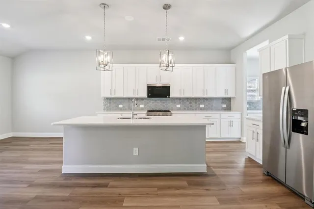 a view of kitchen with stainless steel appliances granite countertop a stove a refrigerator and a sink