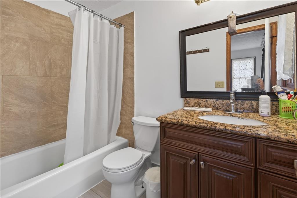 6728 Angels Lane Tucker, GA 30084 - Photo 26 of 54 a bathroom with a granite countertop sink toilet and shower
