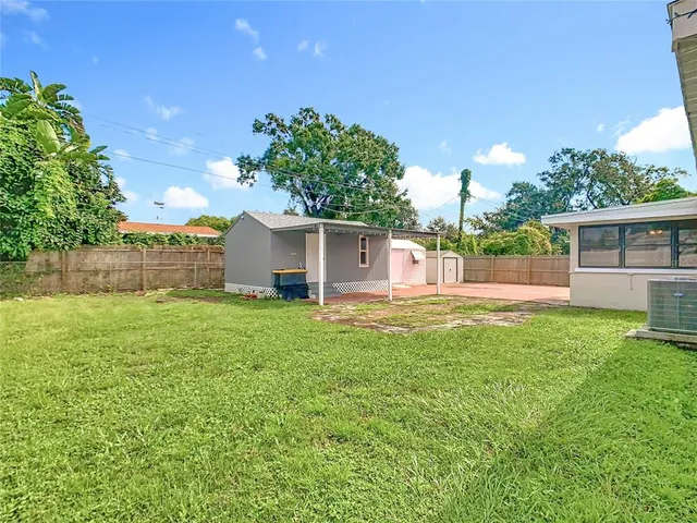 a view of a house with backyard and a tree