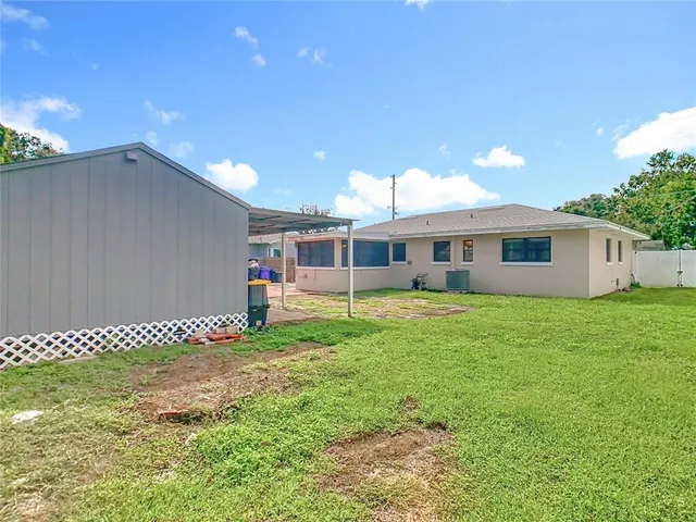 a view of a house with a backyard and a large tree