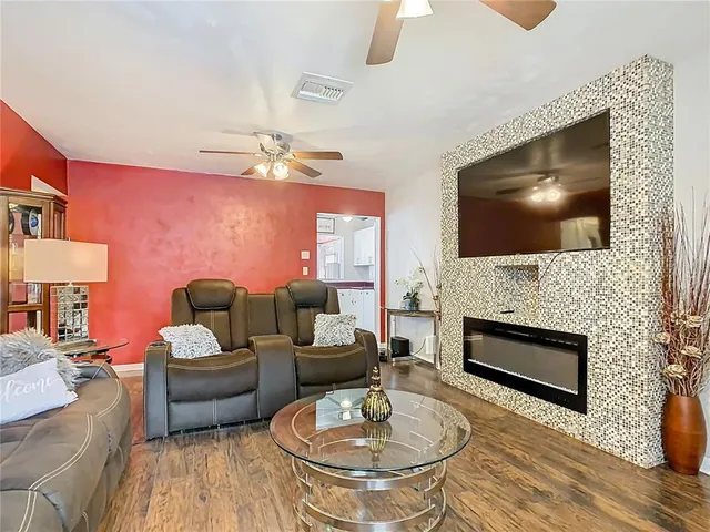 a living room with furniture a fireplace and a flat screen tv