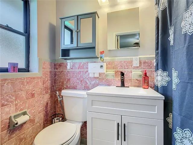 a bathroom with a sink mirror vanity and toilet