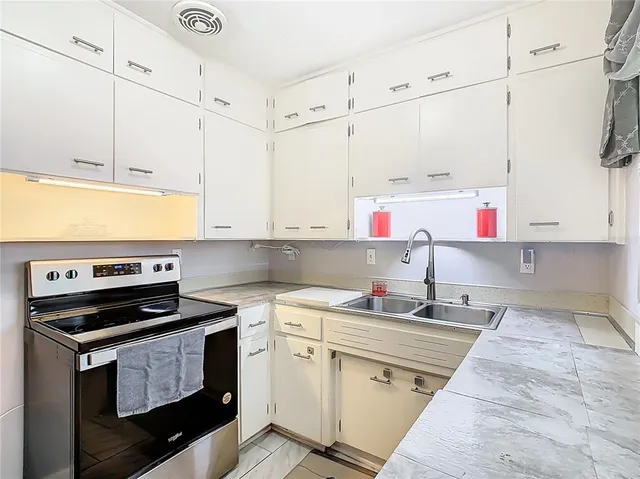 a kitchen with stainless steel appliances a stove a sink and cabinets