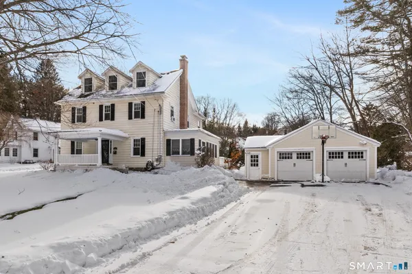 a view of a white house with a snow on the road