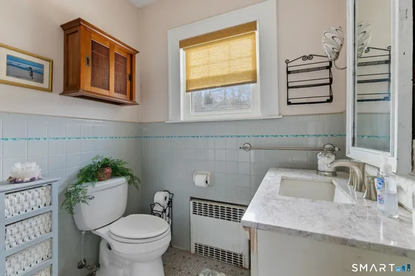 a bathroom with a toilet sink and a mirror