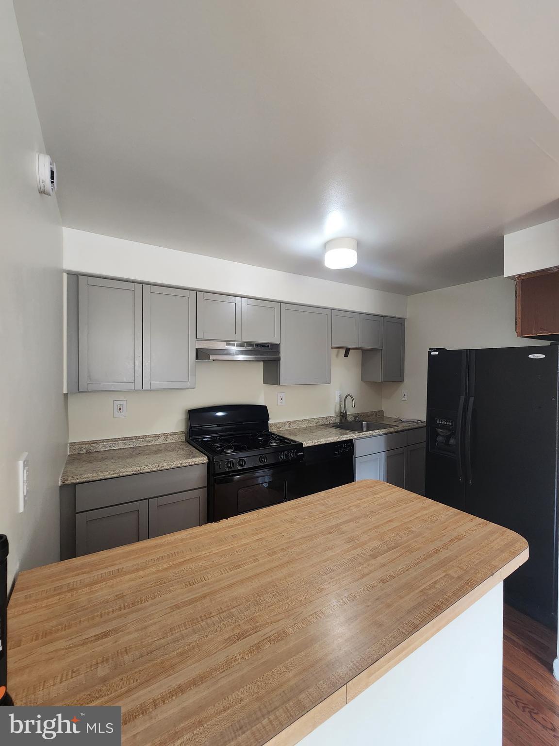 157 Meadowbrook Lane, Unit 2 Brookhaven, PA 19015 - Photo 15 of 17 a kitchen with stainless steel appliances kitchen island granite countertop a refrigerator sink and stove