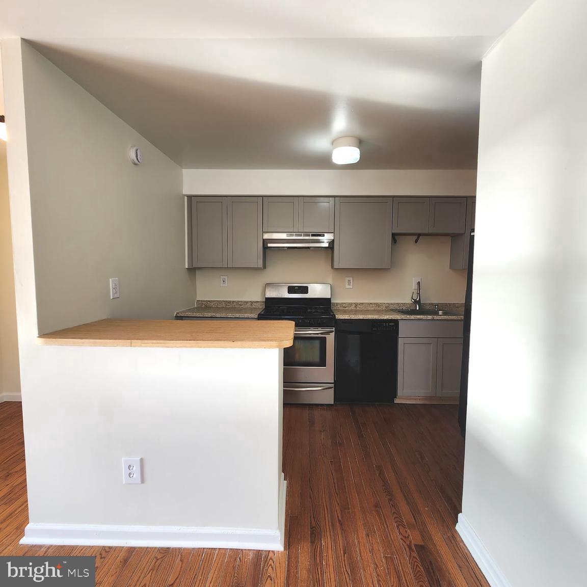 157 Meadowbrook Lane, Unit 2 Brookhaven, PA 19015 - Photo 3 of 17 a kitchen with stainless steel appliances granite countertop a stove a sink and a microwave