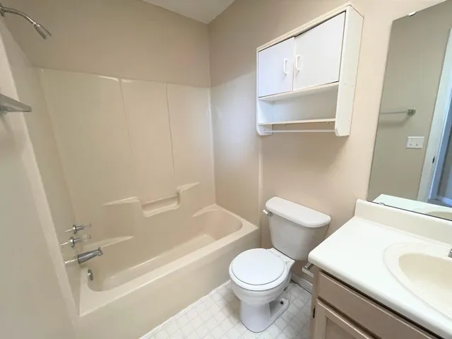 a white toilet sitting next to a bath tub