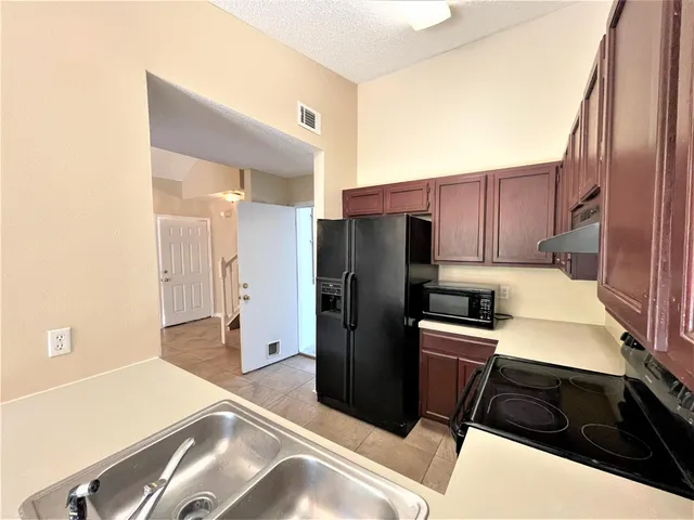 a kitchen with a refrigerator stove and cabinets