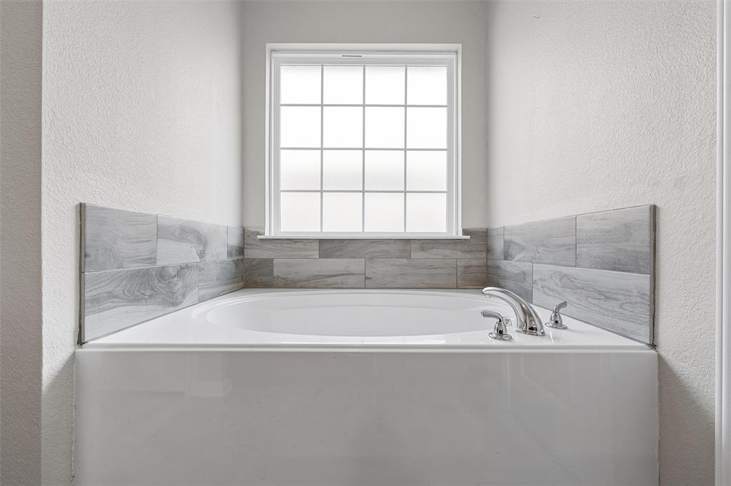 3921 Centerfire Road Waco, TX 76705 - Photo 14 of 16 a white bath tub sitting in a bathroom next to a window