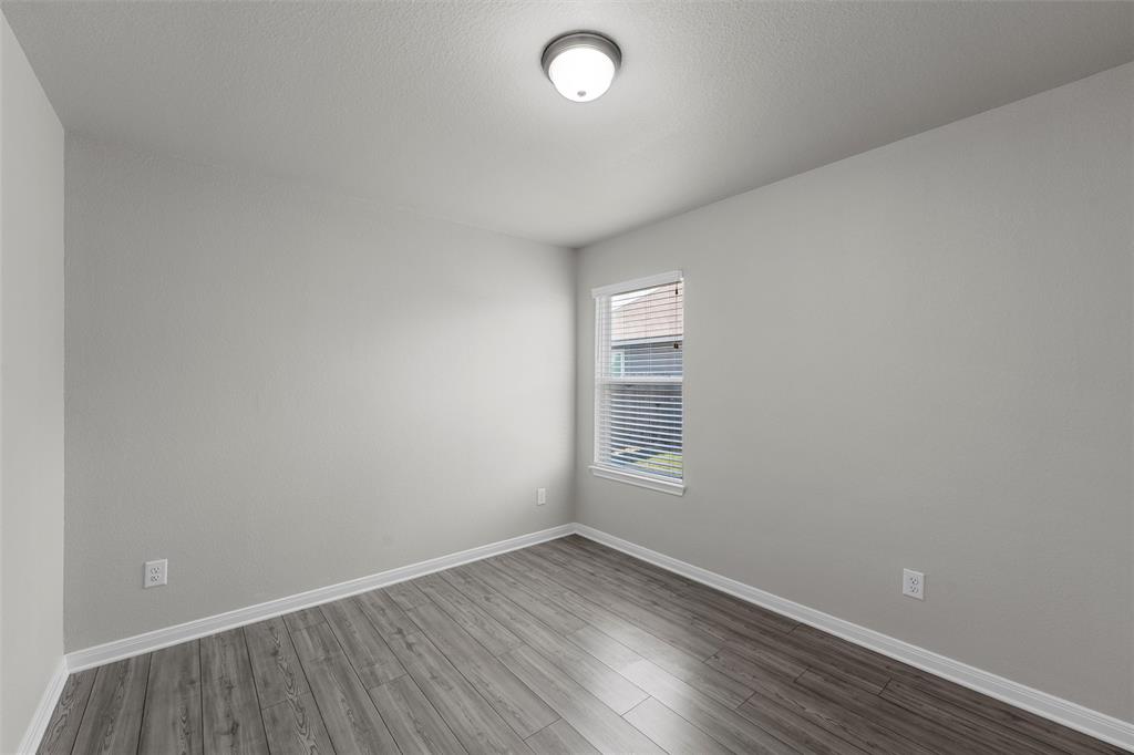 3921 Centerfire Road Waco, TX 76705 - Photo 3 of 16 an empty room with wooden floor and windows