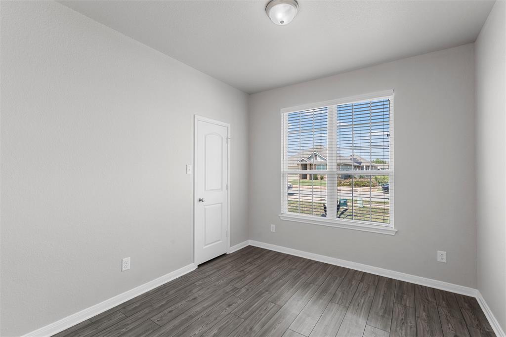 3921 Centerfire Road Waco, TX 76705 - Photo 4 of 16 an empty room with wooden floor and windows
