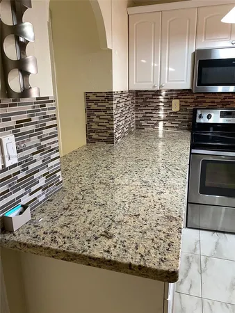 a kitchen with granite countertop a stove and a microwave