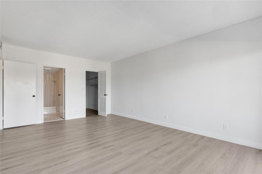 2500 East Las Olas Boulevard, Unit 406 Fort Lauderdale, FL 33301 - Photo 18 of 29 a view of an empty room with wooden floor and closet