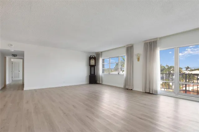 a view of a big room with wooden floor and windows