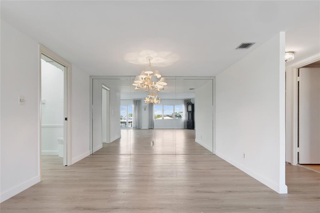 2500 East Las Olas Boulevard, Unit 406 Fort Lauderdale, FL 33301 - Photo 5 of 29 a view of a hallway with wooden floor and a kitchen