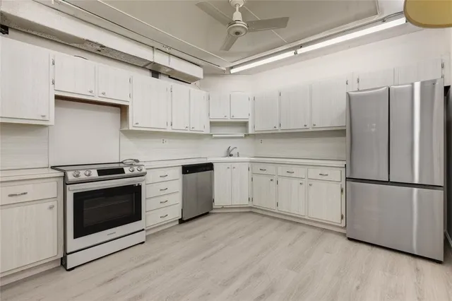 a kitchen with stainless steel appliances white cabinets and a refrigerator