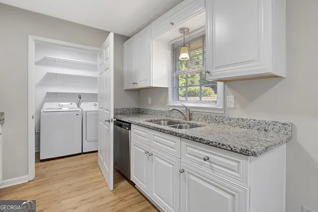a kitchen with white cabinets appliances and a sink