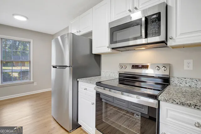 a kitchen with stainless steel appliances granite countertop a stove microwave and refrigerator